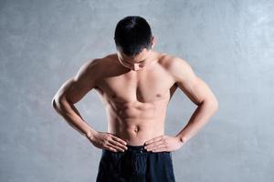 Muscular Asian man posing on gray background photo