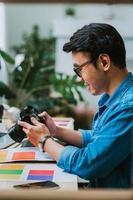 joven fotógrafo asiático revisando su foto