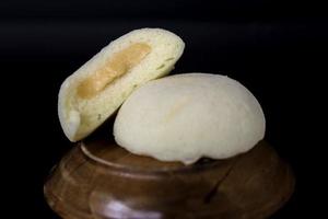 Bakpia Kukus Cake or Steamed Bakpia Cake with Cheese Flavour on wooden plate isolated on white background. photo