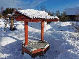 winter day in the Russian village snow well blue sky photo