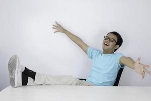 Calm smiling Young Asian Man relaxing at comfortable office chair hands behind head, happy man resting in office satisfied after work done, enjoying break with eyes closed, peace of mind, no stress photo