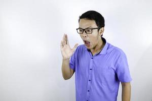 Close up portrait of a young asian man shouting loud and angry facce with arm at his face isolated over white photo