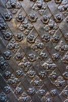 Black forged door, rhombus symmetrical texture. Grunge black background photo