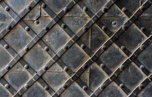 Black forged door, rhombus symmetrical texture. Grunge black background photo