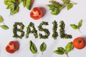 basil and tomatoes on a white marble photo