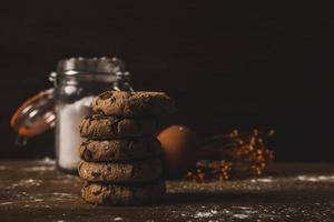 chocolate cookies on a wooden background with some sugar, flavour and eggs
