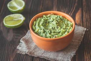 Bowl of guacamole on the wooden table photo