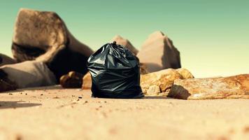 Schwarze Mülltüte aus Plastik voller Müll am Strand video