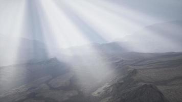 rayos de sol contra el telón de fondo de las montañas video