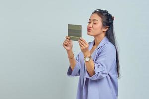 Portrait of cheerful young Asian woman holding palms sending air kiss to vehicle book isolated on white background photo