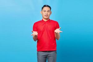 Portrait of handsome young Asian man feeling flustered and confused, with dumb expression and stunned to see something unexpected on blue background photo