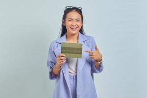 retrato de una alegre joven asiática señalando con el dedo el libro del vehículo aislado de fondo blanco foto