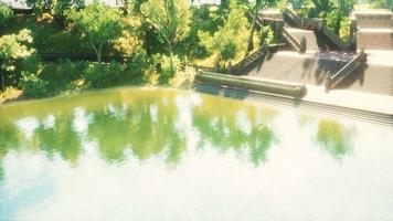 lagoa tranquila emoldurada por um parque florestal verdejante ao sol