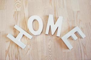 letras blancas de madera en casa con fondo de madera clara foto