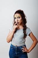 Studio portrait of girl with asian appearance and bright make up with red star on forehead photo