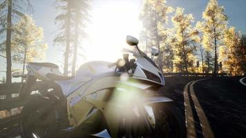 Sportbike en tre road en el bosque con rayos de sol