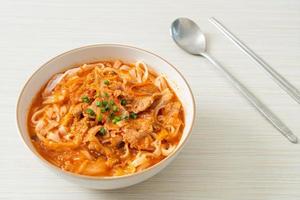 Korean udon ramen noodles with pork in kimchi soup photo