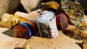 viejo barril de aceite en la playa de arena