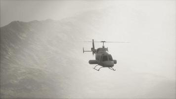 extreme slow motion flying helicopter near mountains with fog