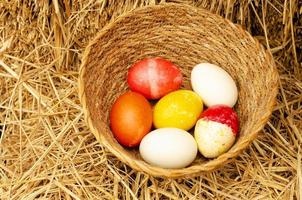 Easter eggs in the basket on straw backgrounds photo