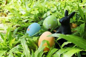 primer plano de huevos de pascua y decoración de conejo sobre fondos de vidrio verde foto