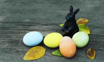 Rabit decoration and fancy easter eggs with atum leaves on wooden backgrounds photo
