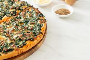 spinach and cheese pizza on wood tray photo