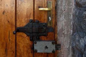 Elements of architectural decoration of ancient buildings, an old metal forged door and lattice gates, a doorknob and a knocker. On the streets in Lviv, public places. photo