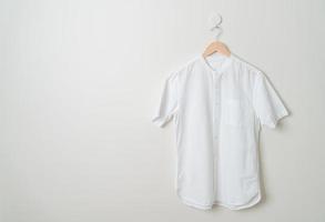 hanging shirt with wood hanger on wall photo