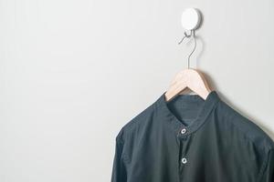 camisa colgante con colgador de madera en la pared foto