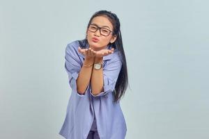 Portrait of charming young Asian woman hold hand palms send air kiss to boyfriend over white background