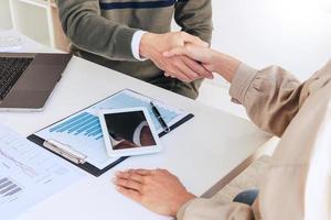 Good deal career and placement concept, successful young businessmen shaking hands after successful negotiation in modern office. photo