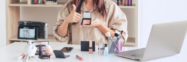 blogger de moda de belleza de maquillaje grabando un video que presenta cosméticos de maquillaje en el hogar influenciador en el concepto de redes sociales. foto