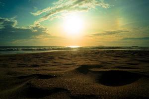 paisaje de playa de arena del océano al atardecer foto