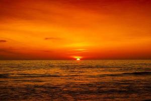 Beautiful sunset over ocean with orange and red sky photo