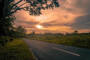 Rural sunset landscape with empty road photo