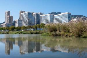 The river reflects the modern city buildings under the blue sky photo