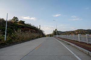 A road with two rows of street lights leading to the distance was photographed in the middle photo