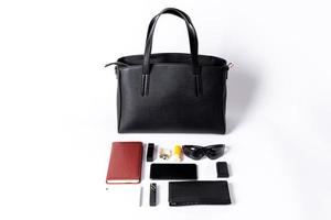 A black leather bag shows what you can hold on a white background photo