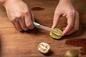 Cut ripe kiwi fruit on a wooden table.