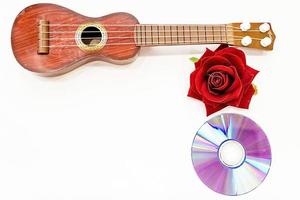 Acoustic guitar and red rose flower, isolated on white photo