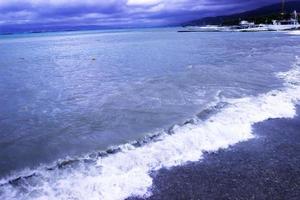 through the clouds over the sea a ray of sunshine makes its way photo