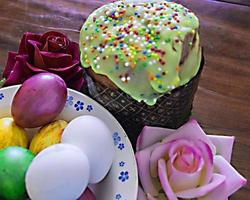 Sweet Easter cakes with colorful eggs on table in room photo