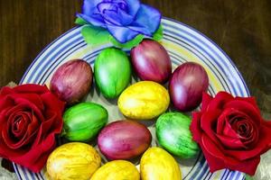 un montón de hermosos y coloridos huevos de pascua en un plato foto