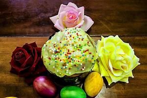 Sweet Easter cakes with colorful eggs on table in room photo