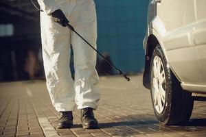 Cleaning and Disinfection of vehicles amid the coronavirus epidemic Car cleaning and disinfection Infection prevention and control of epidemic Protective suit and mask photo