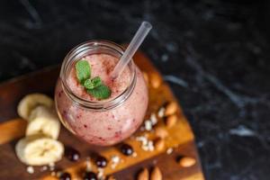 batidos recién preparados de plátano y mora en botella. dieta, estilo de vida saludable foto