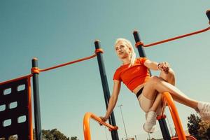 beautiful blonde is engaged on the uneven bars photo