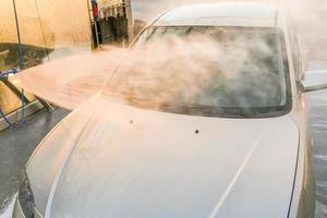 lavado manual de autos con agua a presión en lavado de autos afuera. coche de limpieza con agua a alta presión. foto