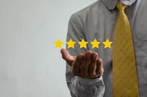 concepto de cliente excelente servicio para satisfacción calificación de cinco estrellas con pantalla táctil de hombre de negocios. sobre comentarios y críticas positivas de los clientes. foto